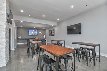 a community room with tables and chairs and a tv in the corner